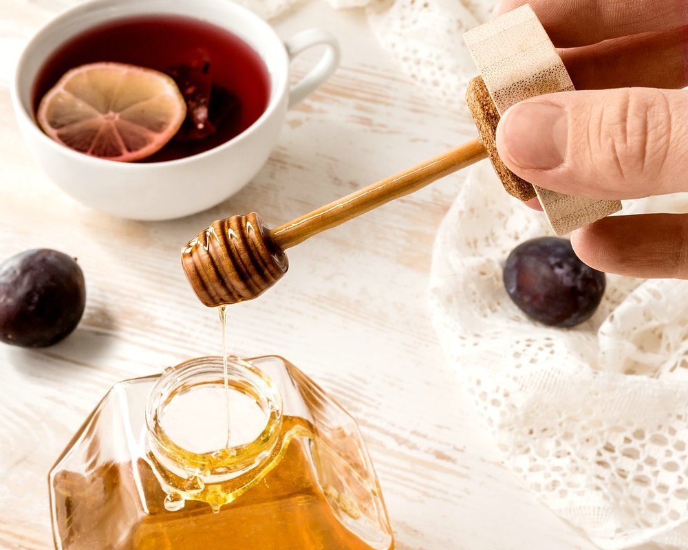 Šestiúhelníková sklenice na med s dřevěnou naběračkou